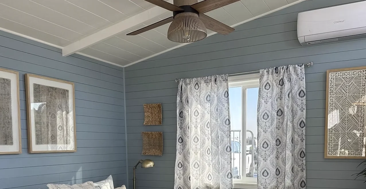 Inside a tiny home with blue walls and a modern ceiling fan